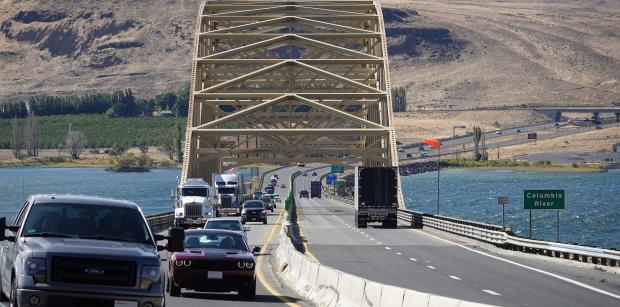 A view of Vantage Bridge, a large bridge that crosses the Colombia River, from the roadway. Cars and trucks cross the bridge on both sides.